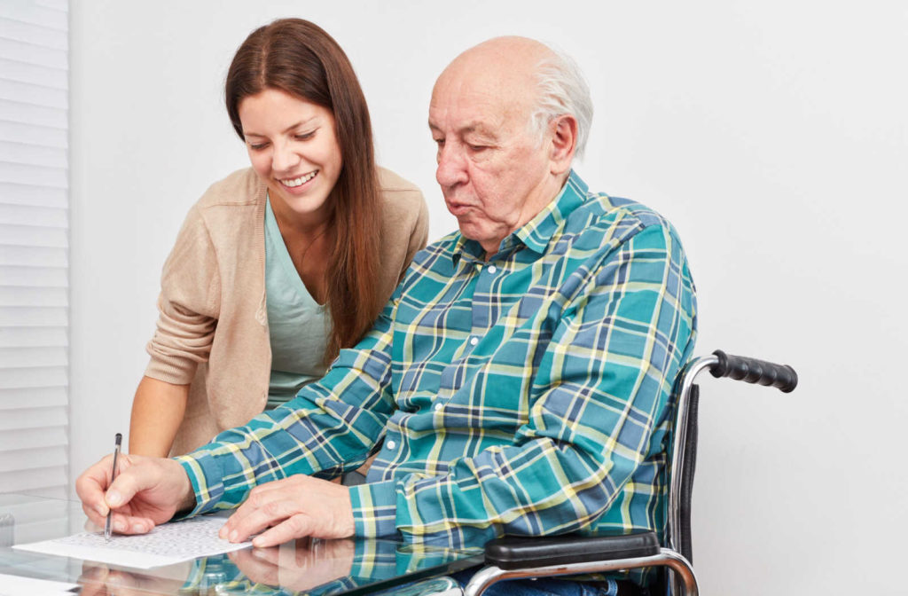 A female nurse assisting a memory care patient with a puzzle