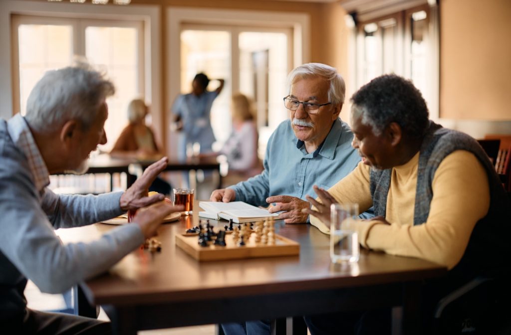 Three older men playing chess.
